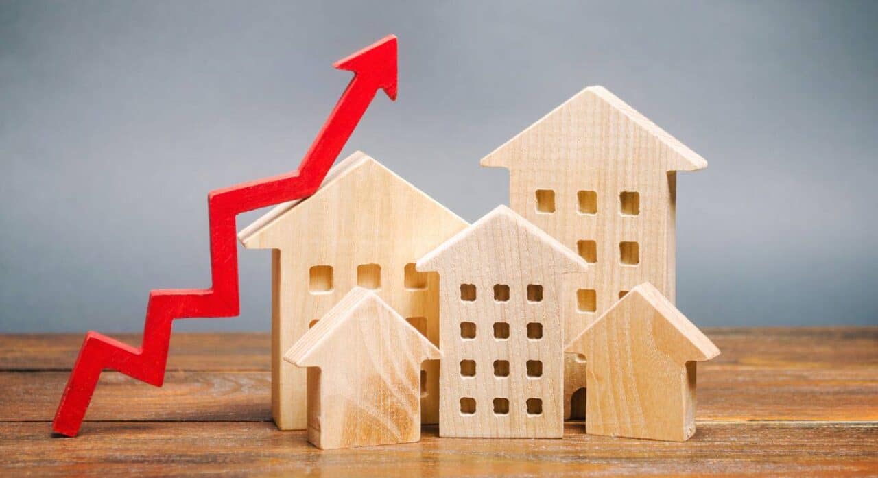 small wooden models of houses with a growth factor arrow beside them